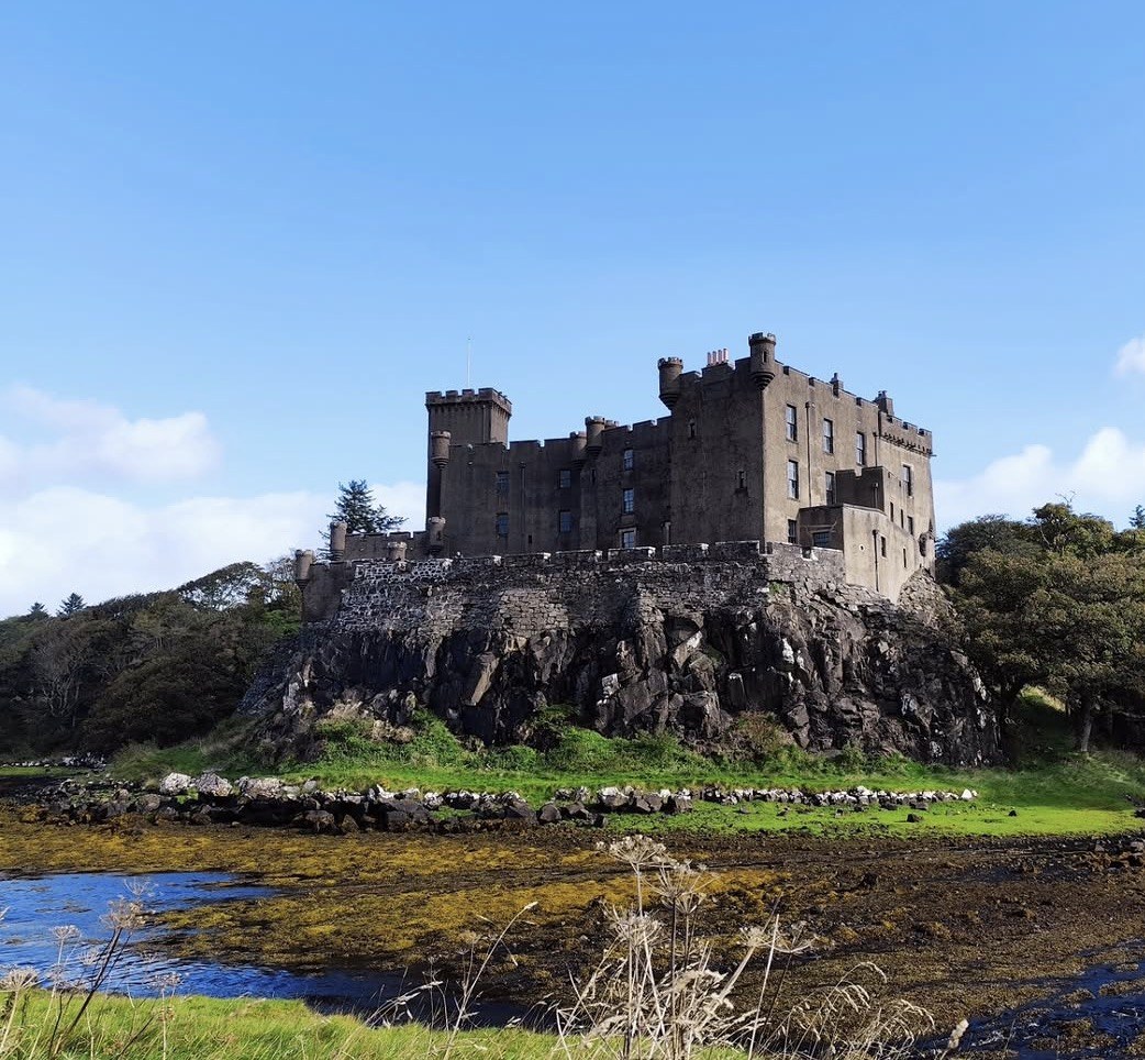 Castello di Dunvegan sulla sua rupe sopra il Loch Dunvegan con la bassa marea