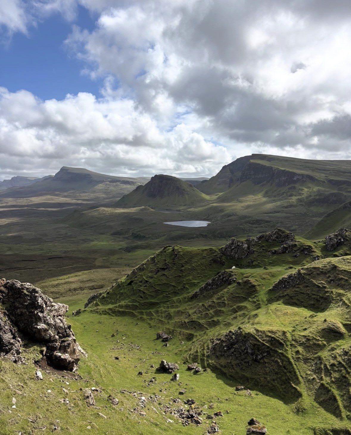 Altopiano erboso dell'Isola di Skye con piccolo lochan e nuvole sparse
