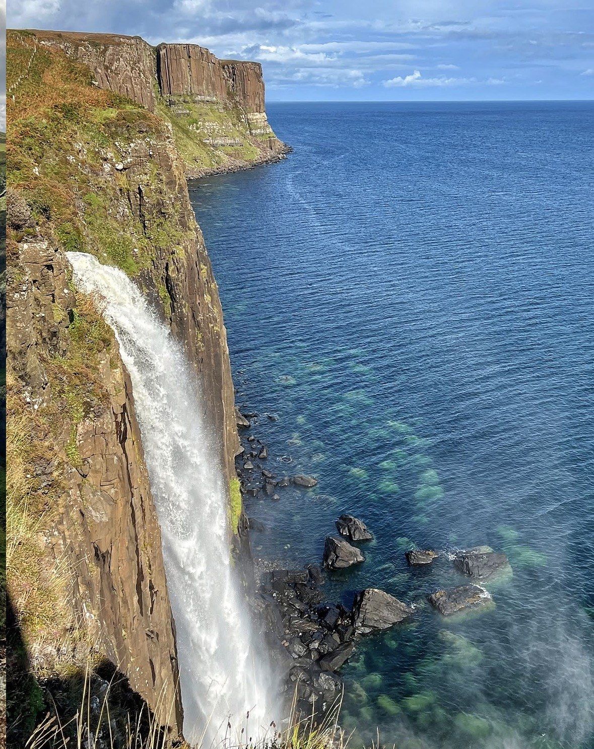 Cascata di Mealt precipita dalla scogliera nel mare turchese di Skye